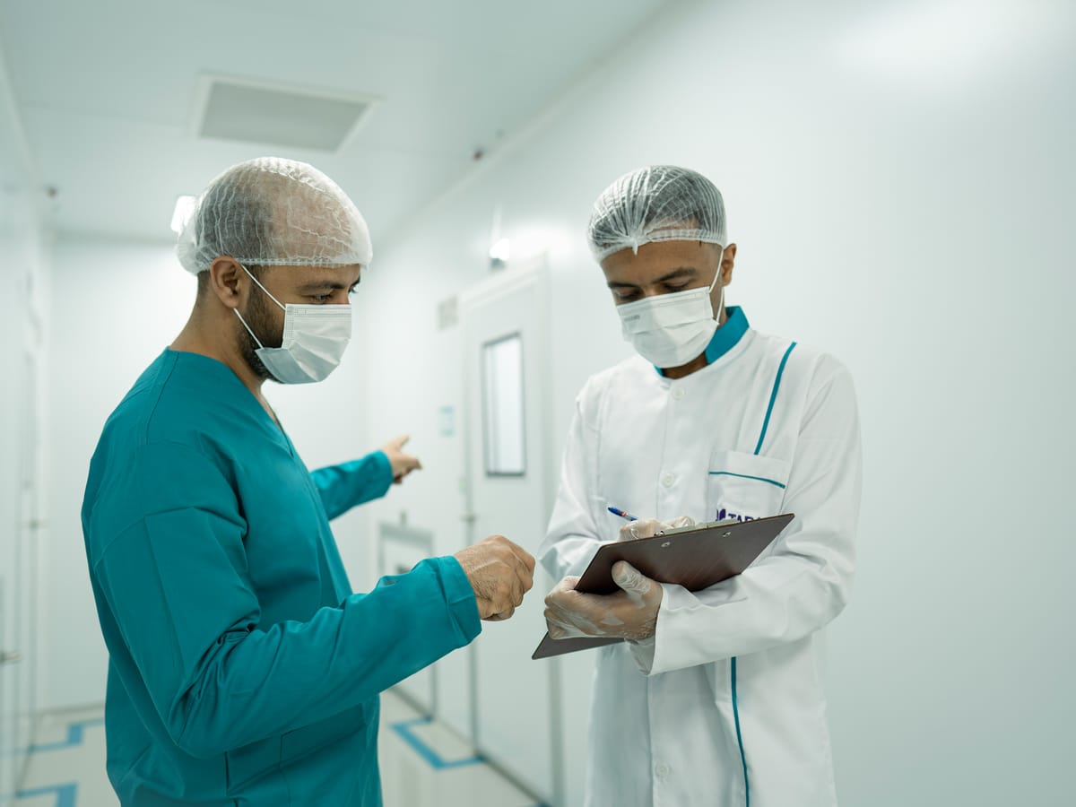 Two clinicians reviewing notes in a clinical corridor